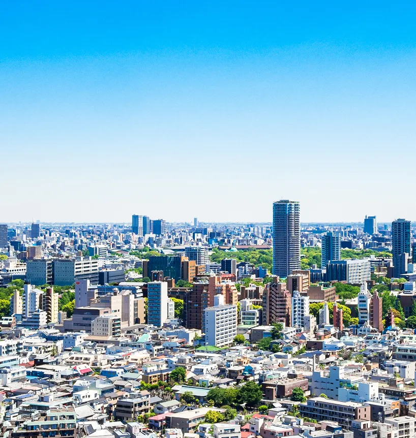 青空の下に広がる大規模な都市景観と高層ビル群